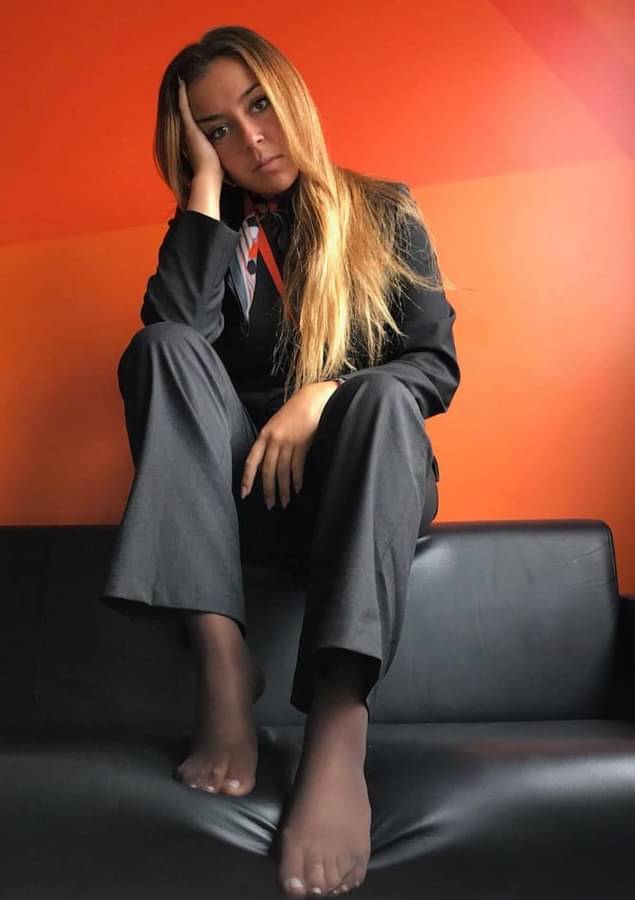 Bionda in tailleur grigio e piedi velati